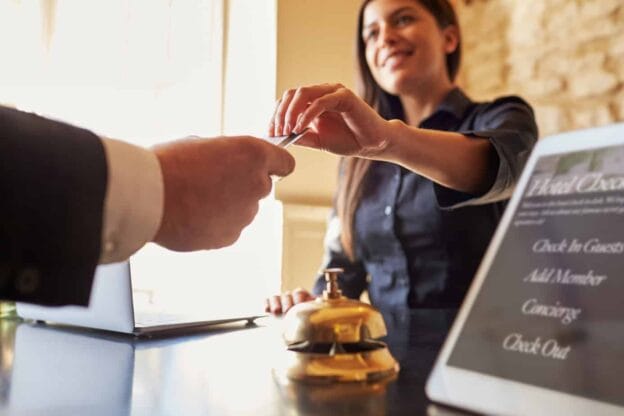 guest takes room key card at check in desk of hotel close up 71533469