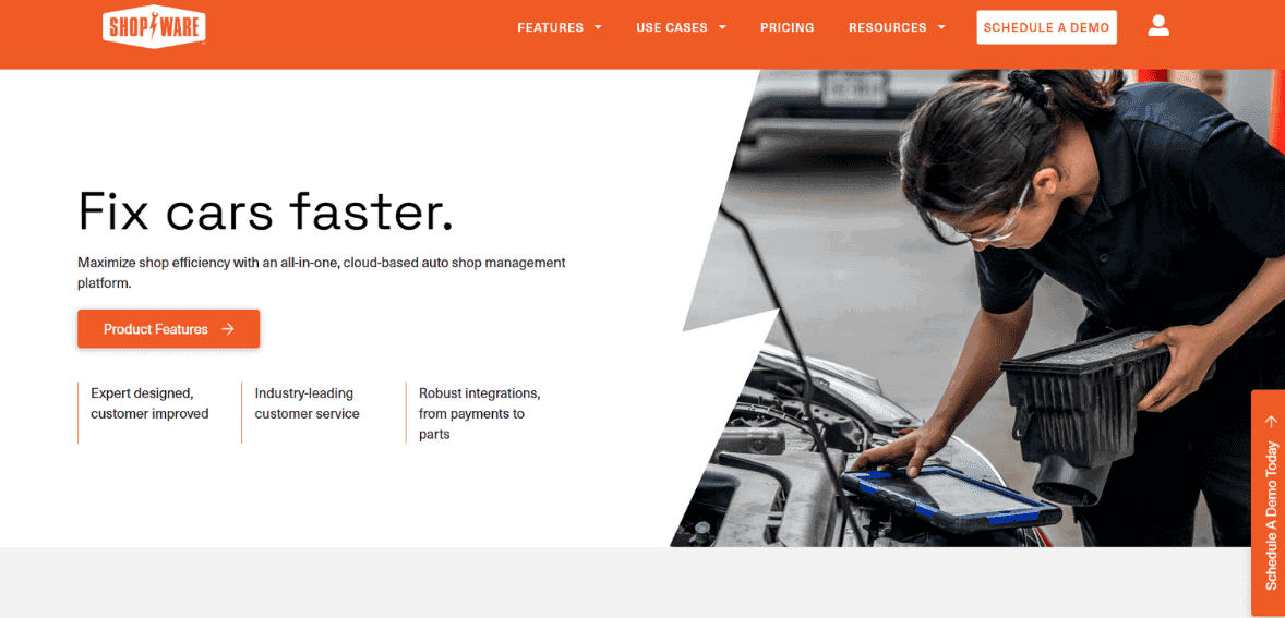 Mobile auto shop repair technician using a payment device at vehicle engine bay.