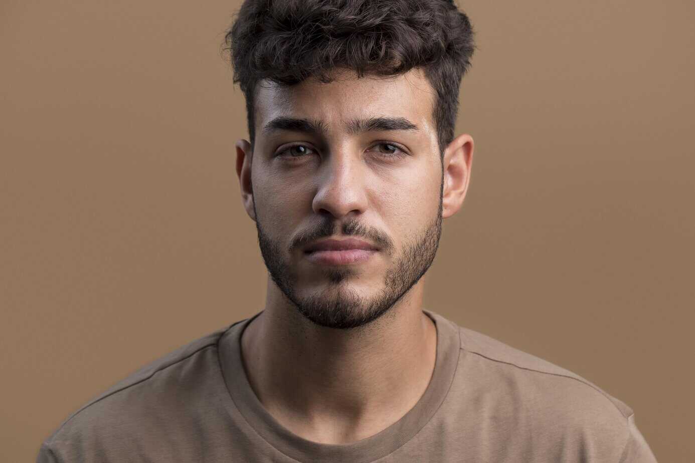 Young man with a confident expression, styled hair, and beard, symbolizing trust in payment processing services.