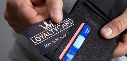 Secure credit card payment being processed with loyalty card in a wallet, highlighting merchant services.