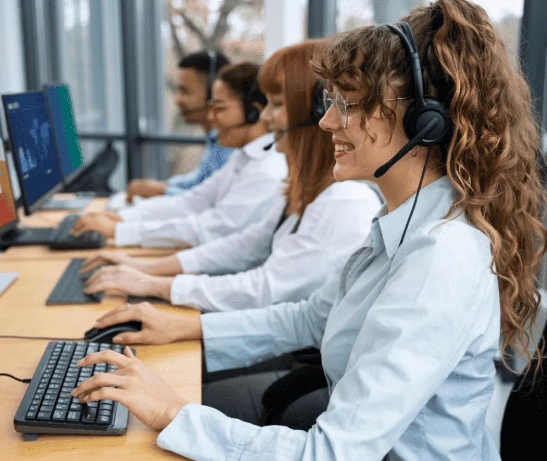 Call center customer support with headsets on computers.