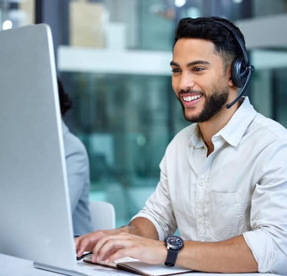 Responsive customer support representative with headset providing payment solutions at a call center.