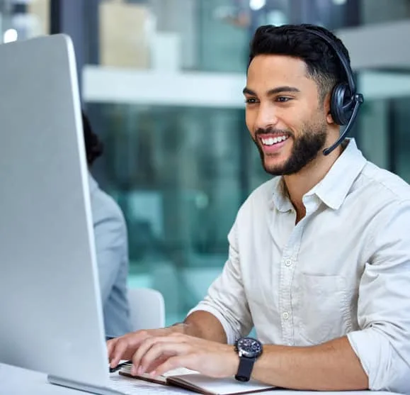 Responsive customer support representative with headset providing payment solutions at a call center.