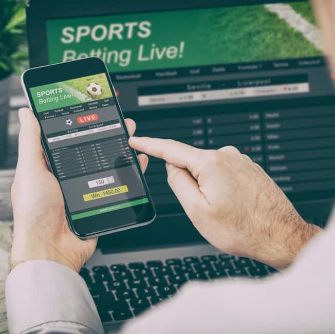 Live sports betting app on smartphone with betting options and odds.