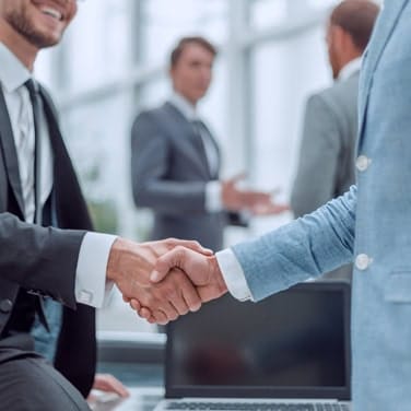 Secure handshake at a business meeting promoting Host Merchant Services for payment solutions.