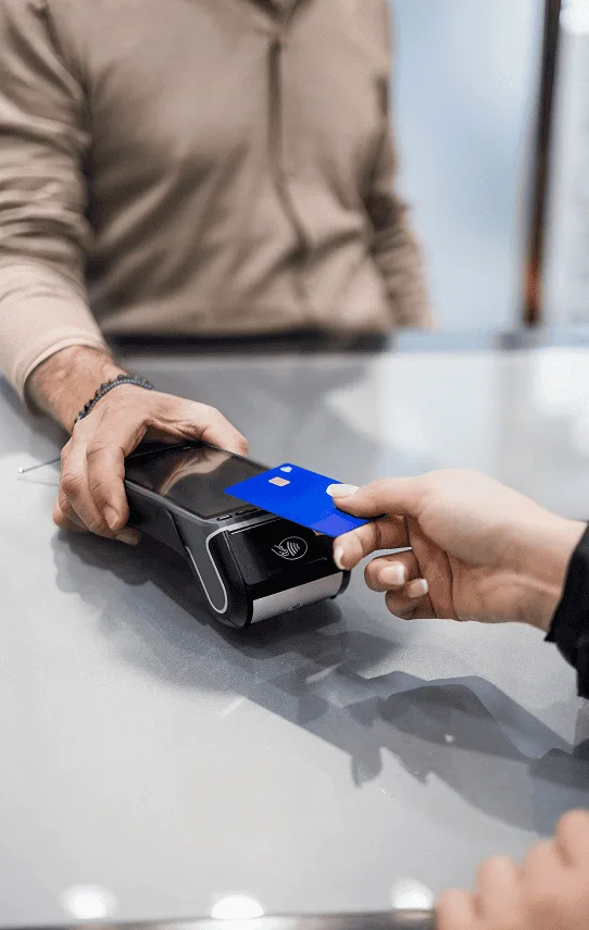Contactless credit card payment with POS terminal at checkout.