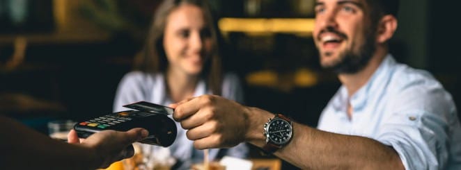 POS credit card payment transaction at restaurant, customer paying bill, friendly service.