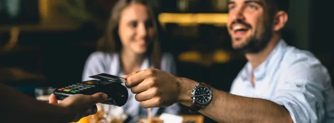 POS credit card payment transaction at restaurant, customer paying bill, friendly service.