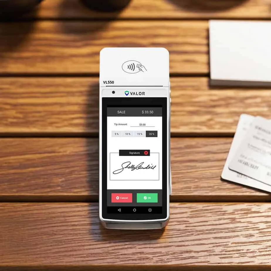 Contactless payment terminal for Host Merchant Services on wooden table.