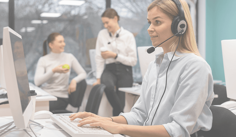 Customer support representative assisting callers at a modern call center.