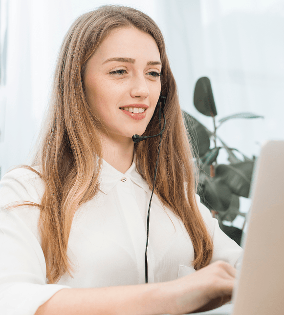 Customer support representative with headset working at computer for merchant service assistance.