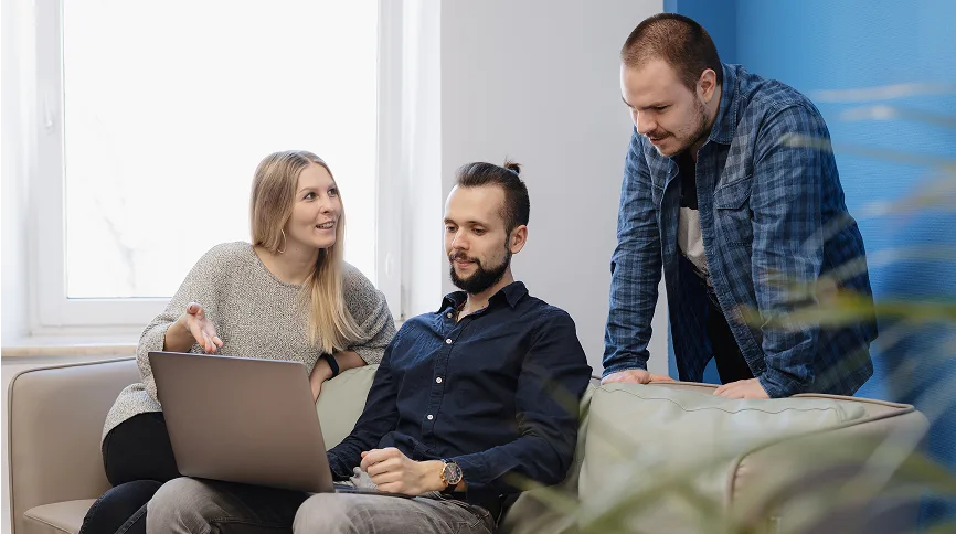 Business meeting with laptop and financial discussion, modern office environment.