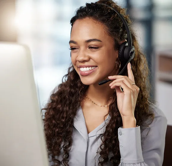 Responsive customer support representative with headset providing payment solutions at a call center.