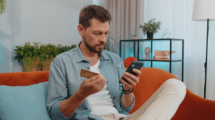 Seated man using smartphone for payment processing or business management.