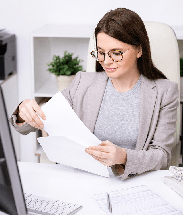 Efficient professional woman reviewing financial documents at work, emphasizing business and payment solutions.