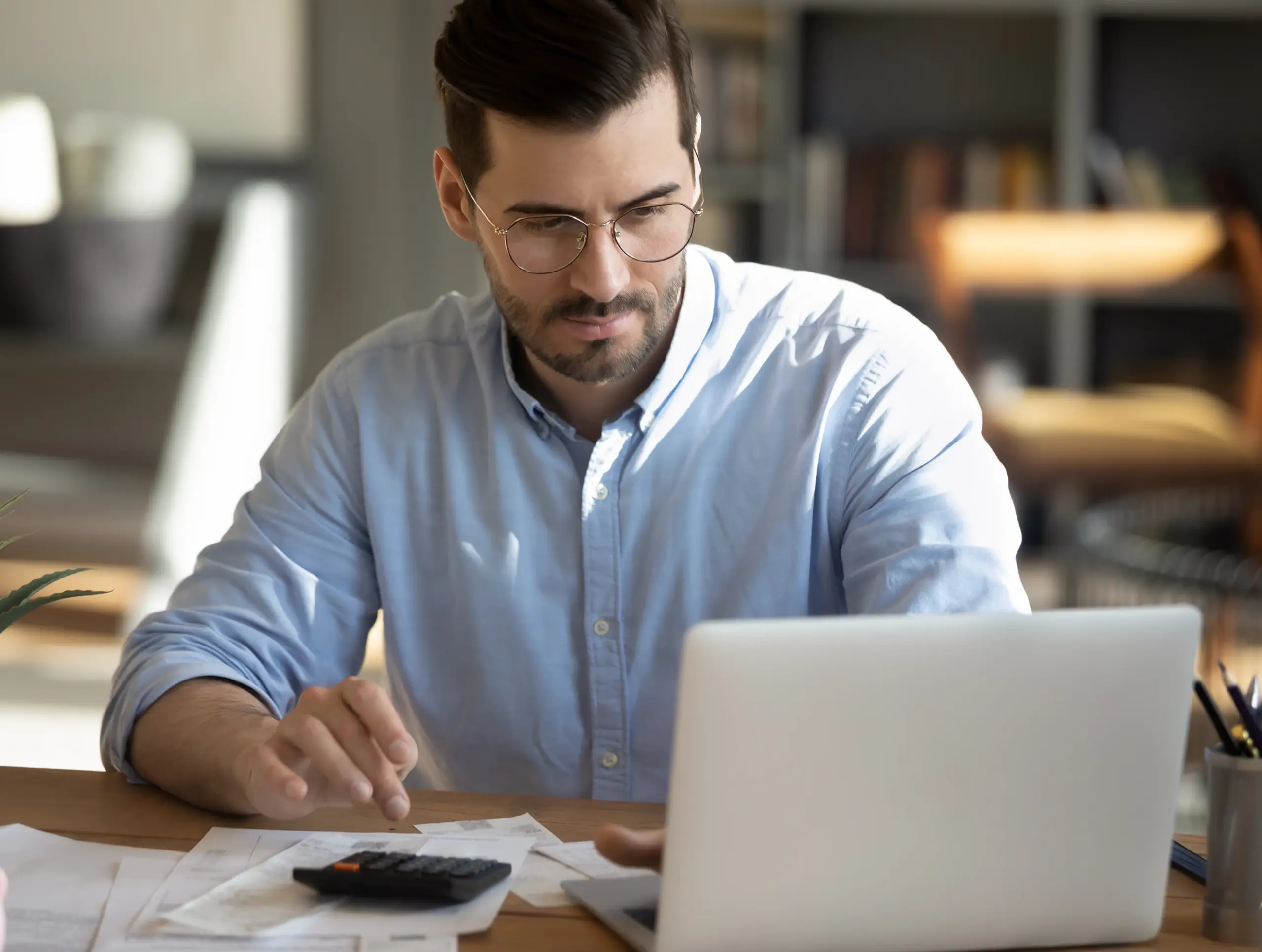 Person calculating interest rate on laptop scaled