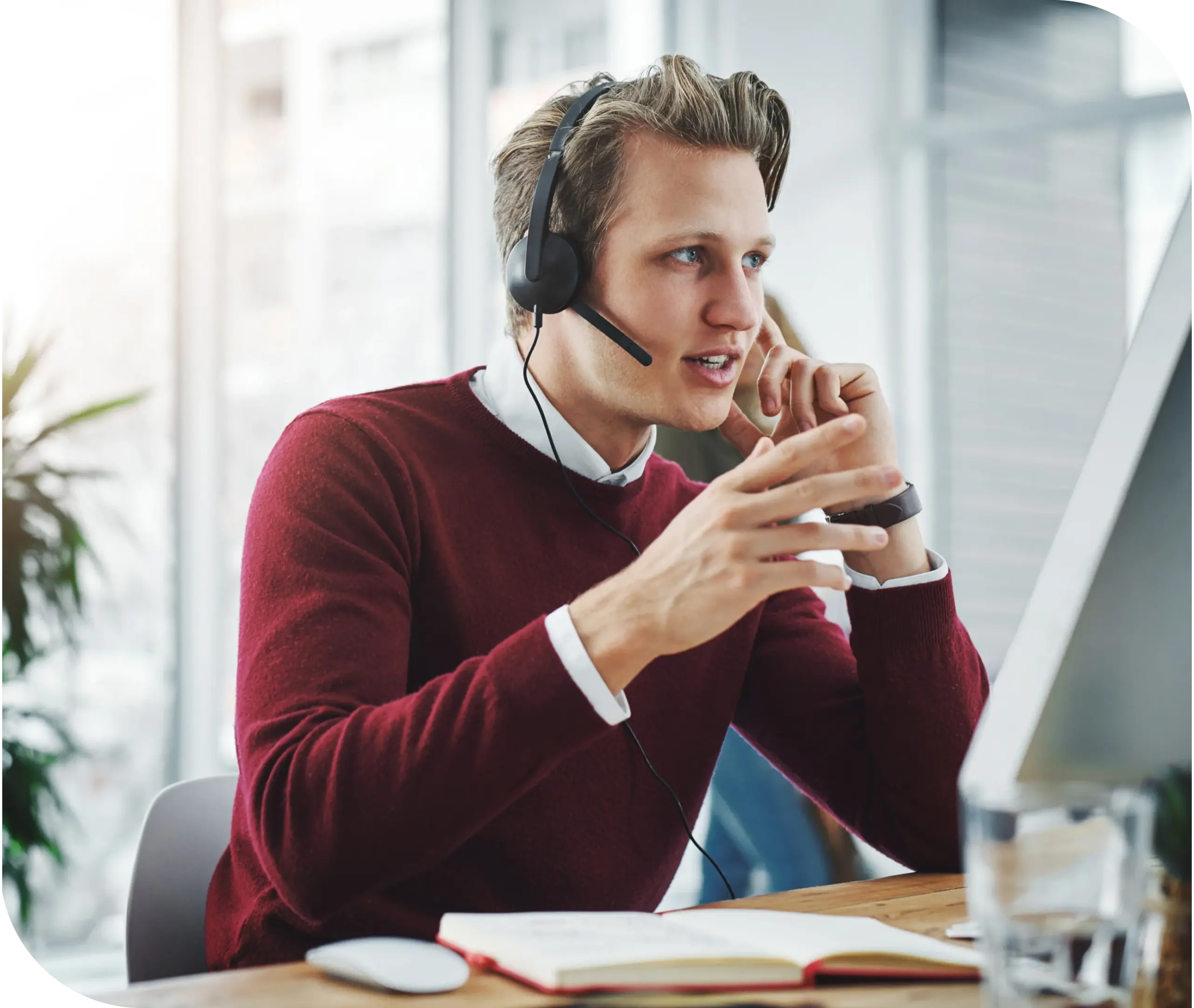 Customer support representative wearing a headset assisting prospective HMS agents with questions about joining the program