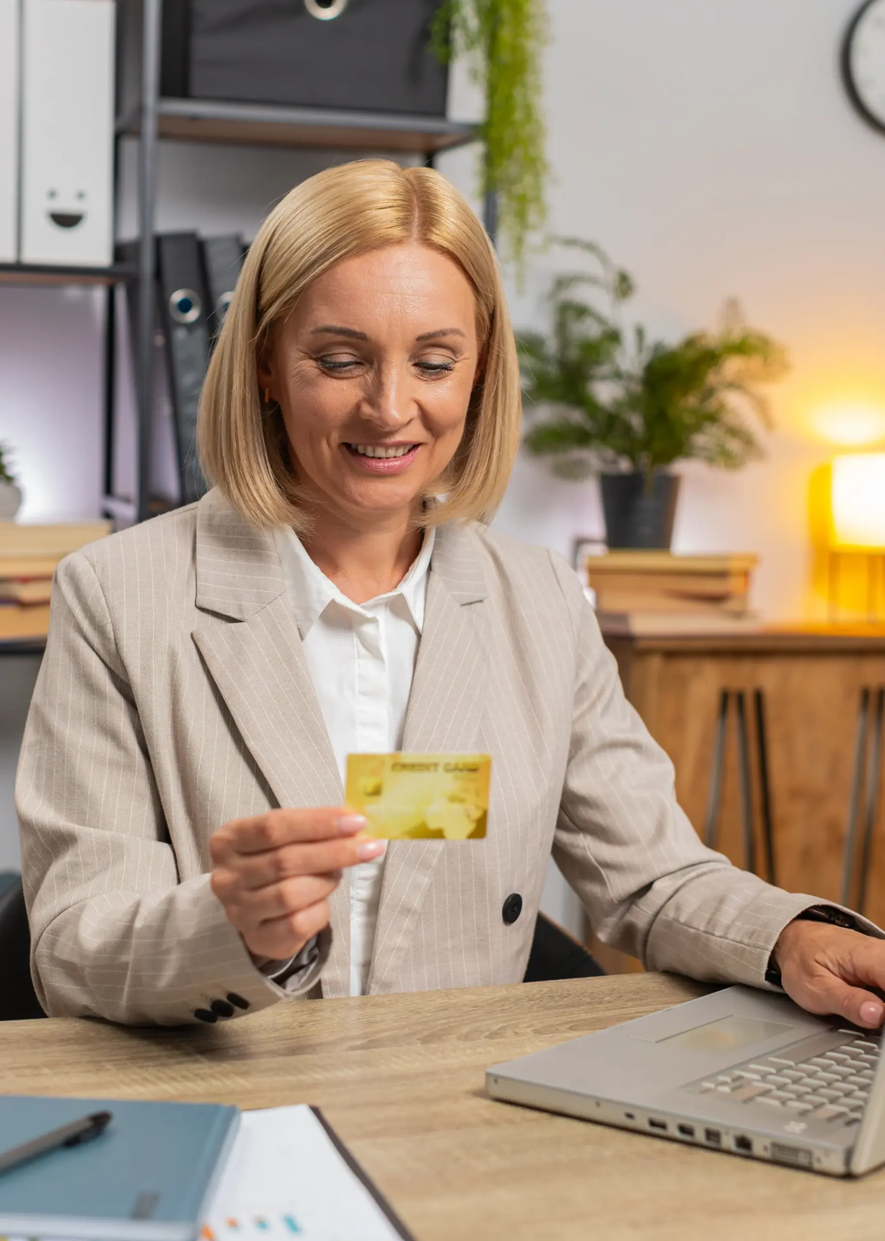 Business professional using a laptop and payment card while exploring ACH and eCheck payment solutions
