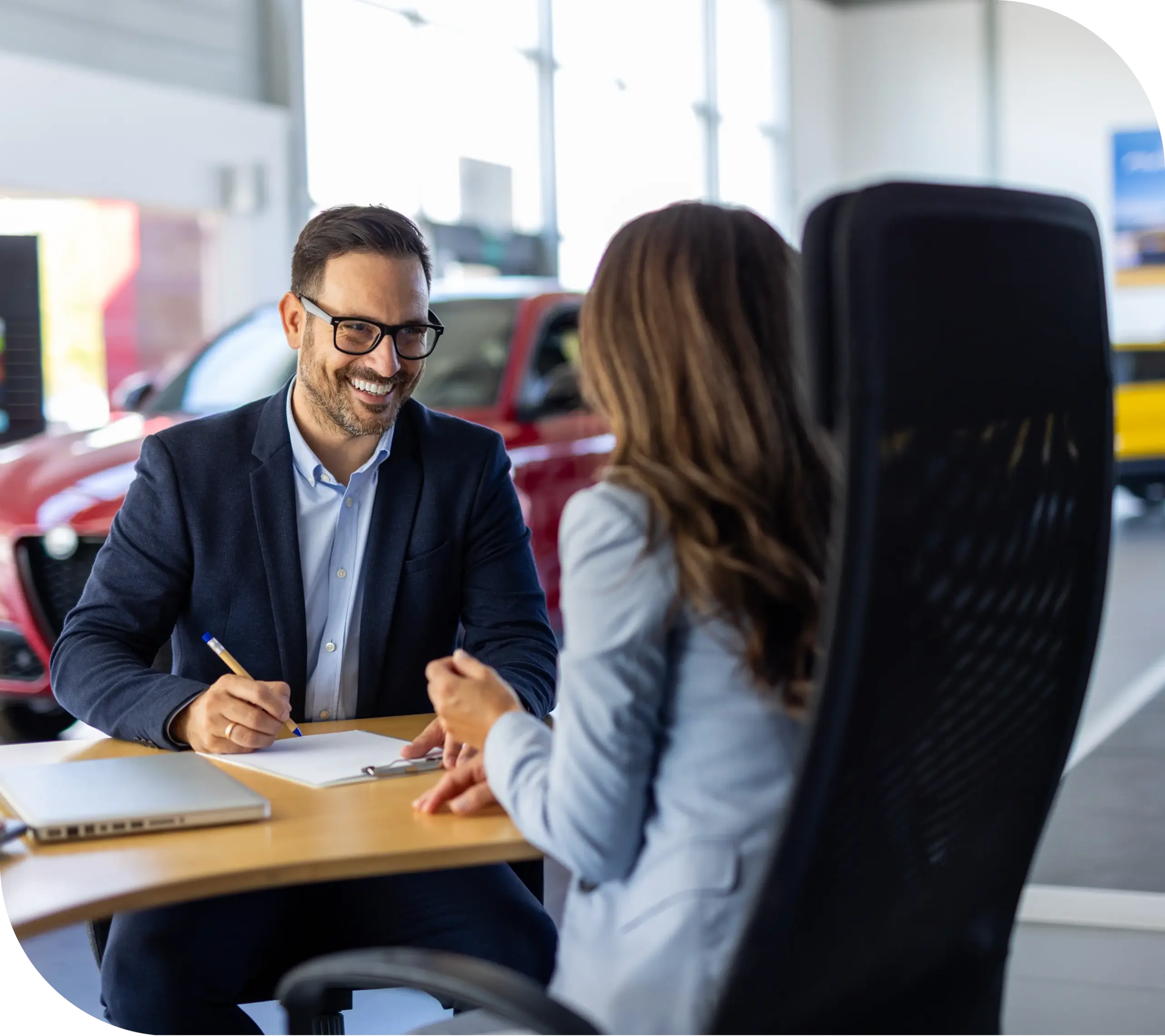Auto dealership representative discussing vehicle warranty services and payment options with a customer during an office consultation