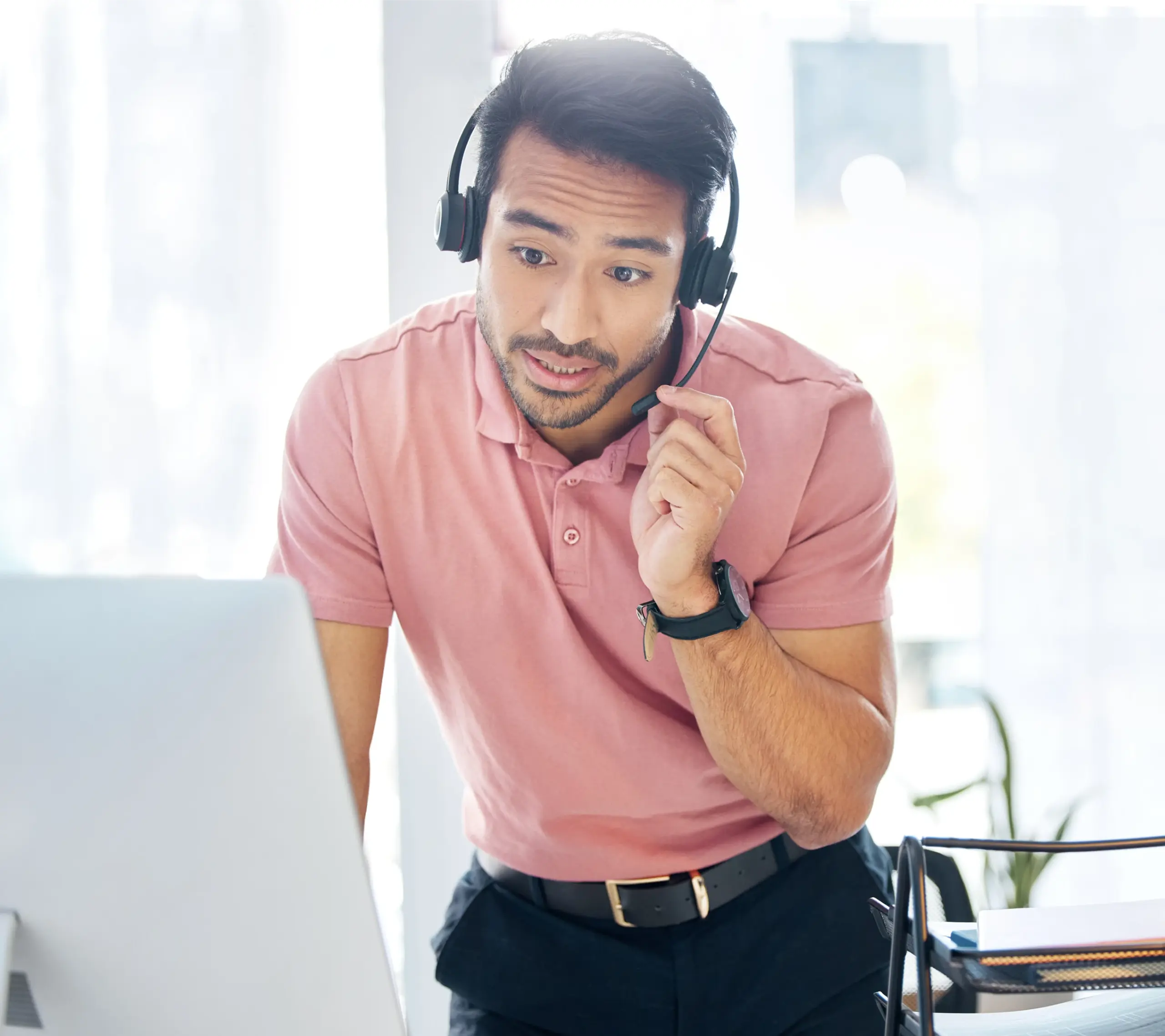 Customer support representative wearing a headset and using a laptop to assist with auto warranty merchant account questions
