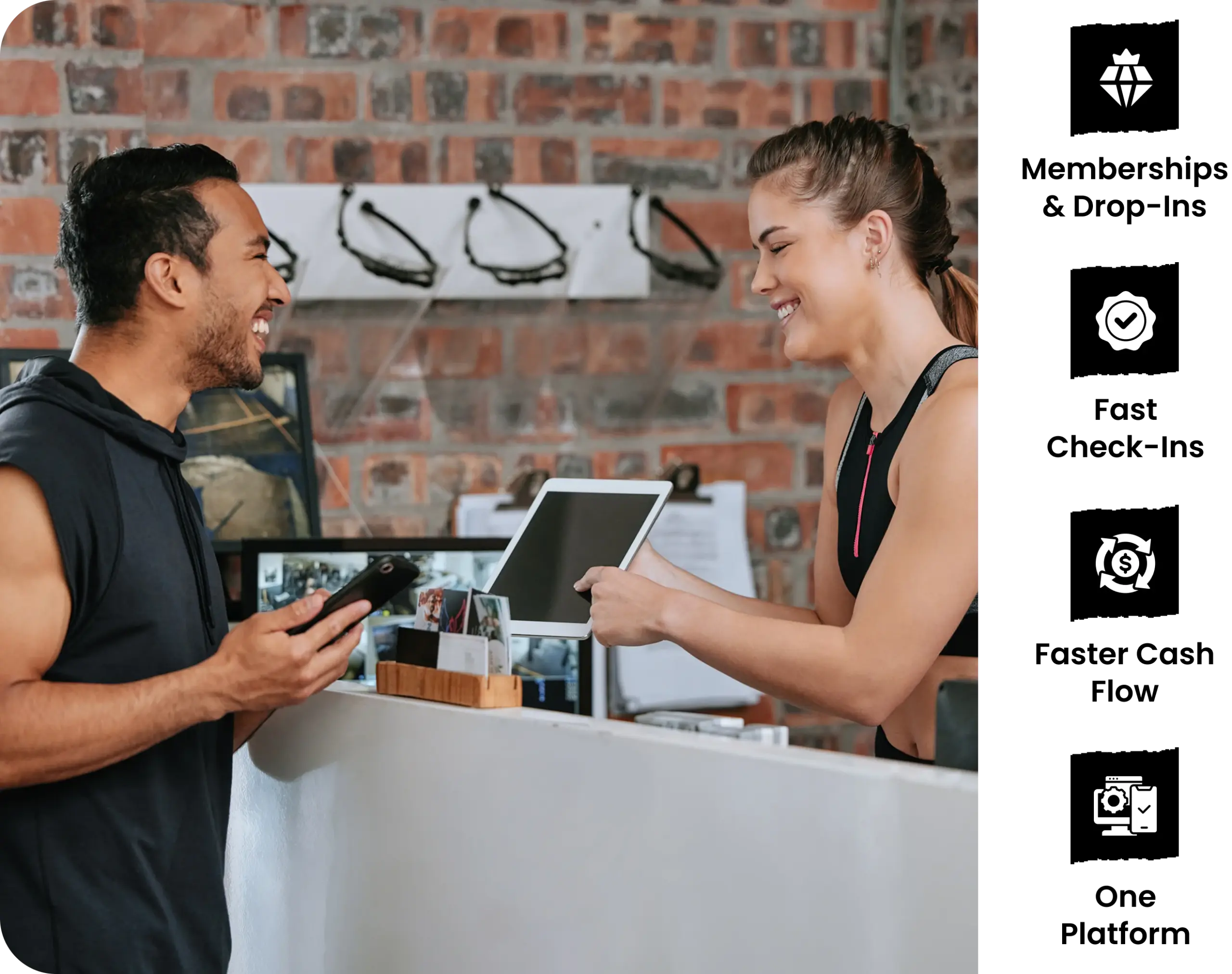 Fitness studio member checking in at the front desk using a smartphone, with staff managing memberships and payments