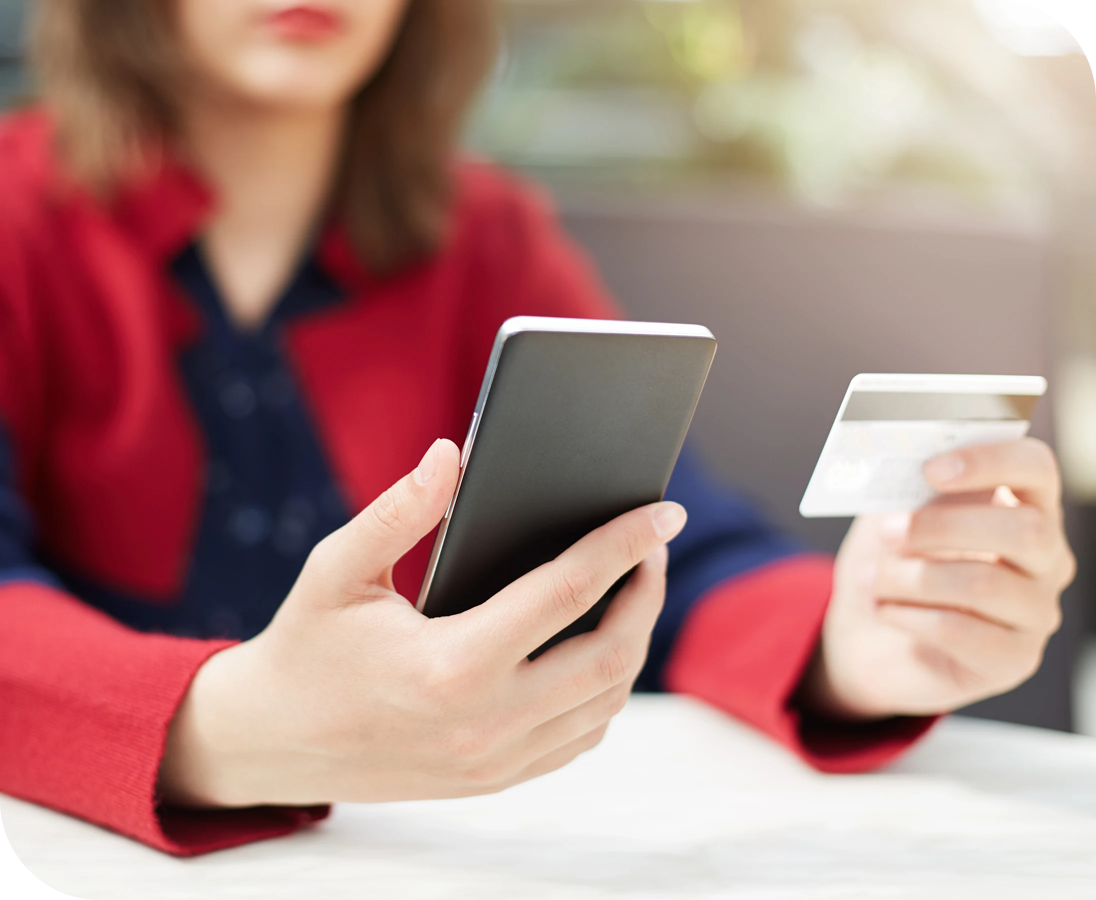 Customer holding a smartphone and credit card to make a secure online payment for credit repair services